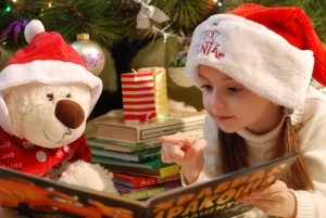 little girl reading a Christmas book