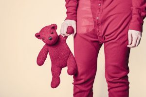 child holding teddy bear before bedtime