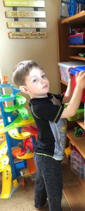 kid putting toys away